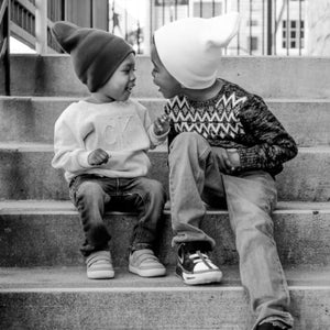Gesprächskultur - zwei kleine Kinder sitzen auf einer Sousterraintreppe und unterhalten sich lebhaft.